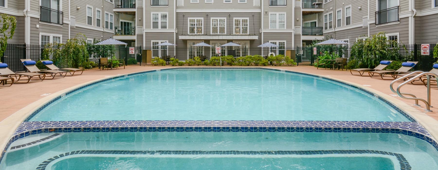 a pool in a courtyard with buildings in the background