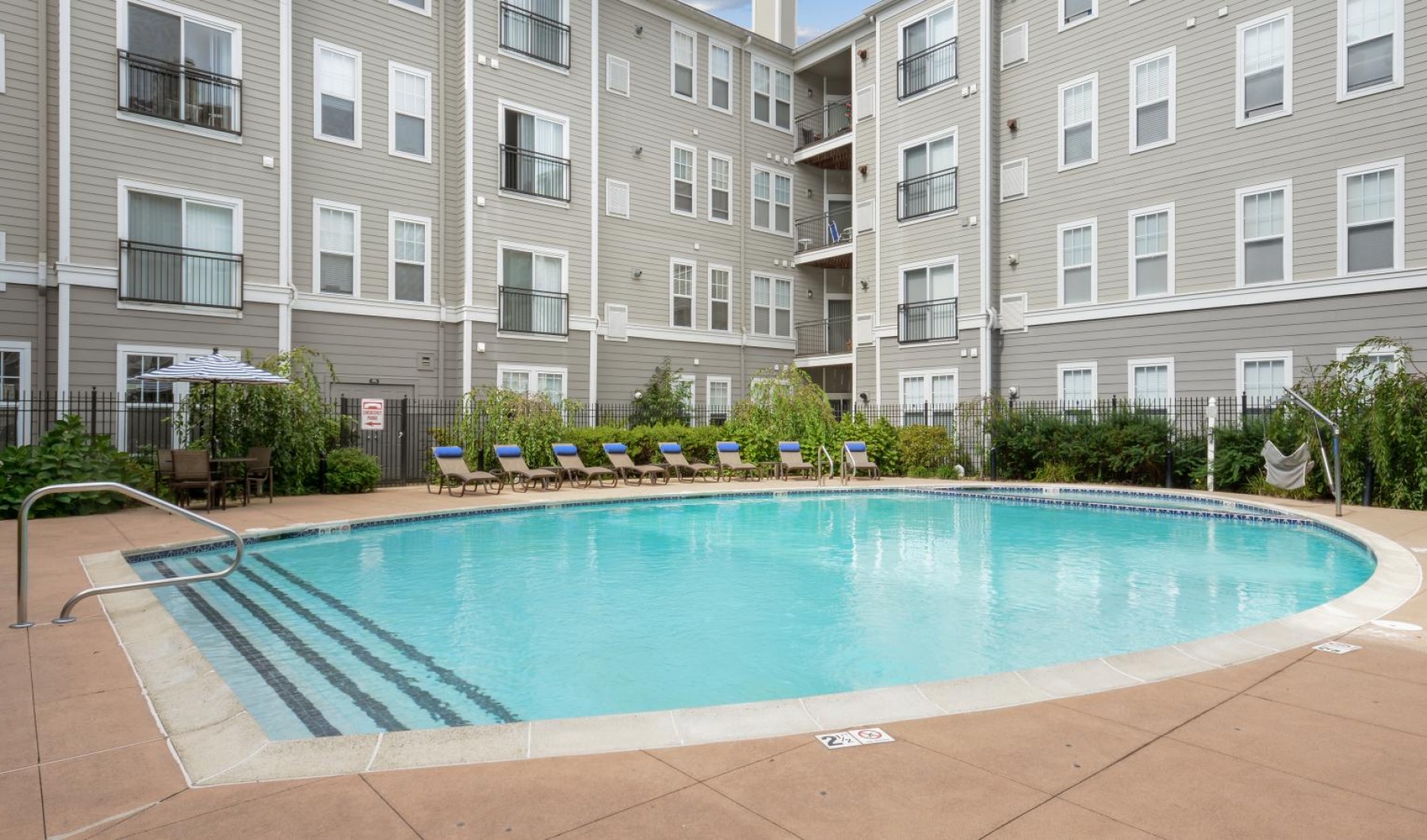 Relax and unwind poolside a swimming pool in front of a building