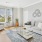 Model living room at Jefferson at Dedham Station apartments in Dedham, MA, featuring wood grain floor paneling.