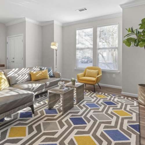 Find your perfect fit at Jefferson at Dedham Station Model living room at Jefferson at Dedham Station apartments in Dedham, MA, featuring couches and windows with blinds.